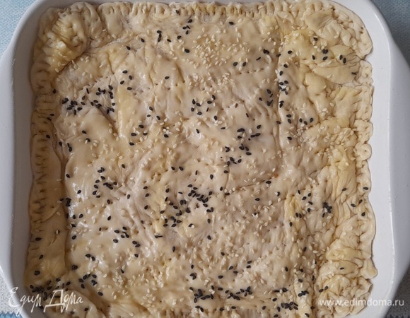 Оставшееся сливочное масло растопить, смазать поверхность пирога. Посыпать семенами кунжута (у меня белые и черные). Поставить пирог в духовку, разогретую до 180°C, на 40–45 минут. Пирог должен красиво подрумяниться.