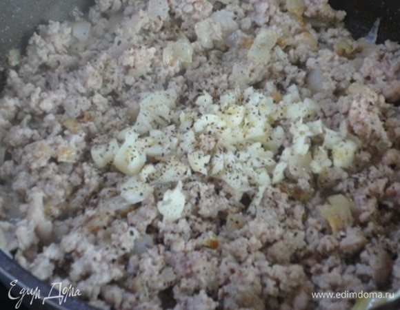 В сковороде разогрейте масло, добавьте лук и жарьте до мягкости. Затем добавьте мясо, посолите его и готовьте, пока не изменит цвет. После чего добавьте чеснок и приправьте черным молотым перцем. Все хорошо перемешайте, посыпьте паприкой и петрушкой, снимите с огня.