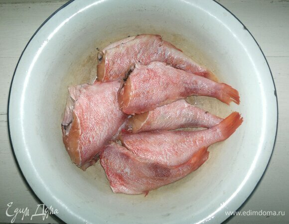 Замороженного морского окуня выньте из морозилки и разморозьте в холодильнике. Если он неочищенный, то почистите и удалите плавники. Затень вымойте рыбу и обсушите.