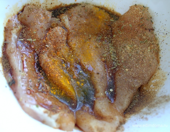 Куриную грудку разрежьте вдоль на пластины, посыпьте специями и полейте соевым соусом.