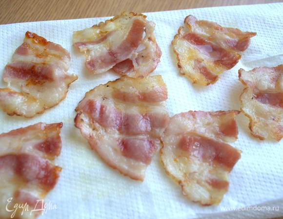 Перенесите на салфетку жареный бекон.