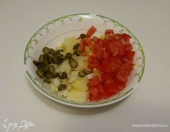 Затем нарезать тонкими кружочками каперсы и добавить их к остальным овощам.