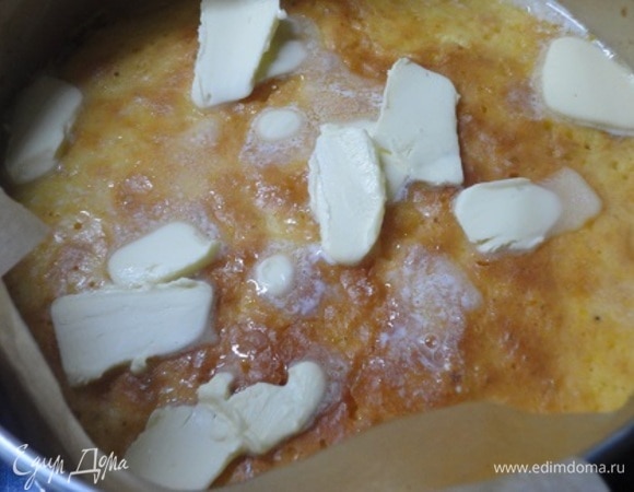 Затем вновь достаньте из духовки, сверху распределите хлопья сливочного масла и продолжайте выпекать еще 10 минут.