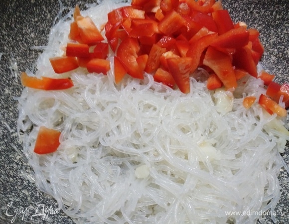 Выложить фунчозу, добавить болгарский перец. Жарить, помешивая, 7–8 минут.