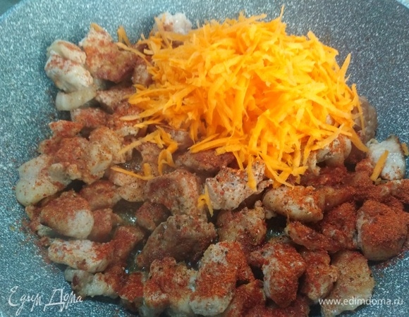Посолить, посыпать перцем и паприкой. Добавить натертую морковь. Пережарить.