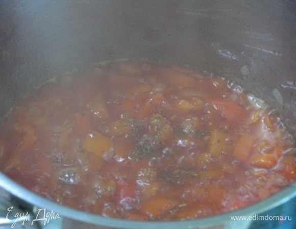 В кастрюле с толстым дном разогреть сливочное и растительное масло и обжарить на нем лук с чесноком до прозрачности. Добавить перец, томатную пасту и пожарить 3 минуты. Затем долить немного фасолевого отвара, добавить специи (кроме паприки) и потушить 5 минут.
