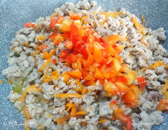 Фарш обжарьте до изменения цвета, добавьте лук и припустите его до прозрачности. Всыпьте натертую морковь и тоже обжарьте до изменения цвета. Посолите, посыпьте все черным перцем, добавьте болгарский перец. Затем обжаривайте овощи с мясом в течение 5 минут.