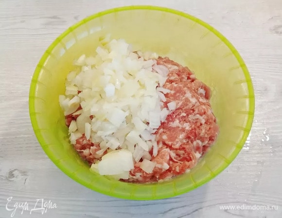 В фарш мелко нарежем лук, добавим специи и воду, тщательно перемешиваем.