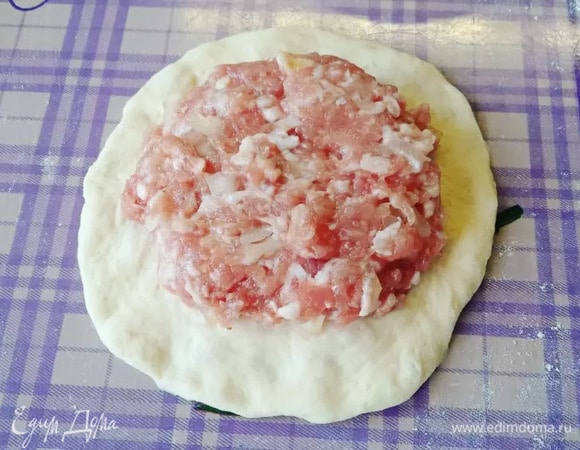 Каждый шарик раскатываем в лепешку, в середину кладем фарш.