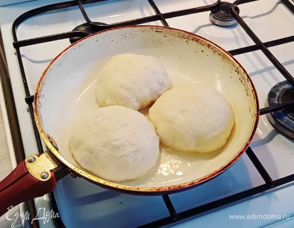 Начинаем жарить беляши узелком вниз на разогретой сковороде с маслом. Готовим на небольшом огне под крышкой 4 минуты с каждой стороны, ориентируемся на свою плиту.