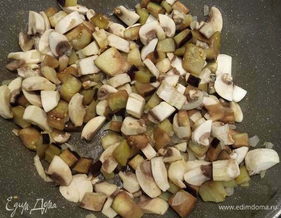 Добавляем мелко нарезанные шампиньоны. У меня были крупные, поэтому я взяла 5 штук. Если мелкие, то берите больше. Шампиньонов должно быть столько же, сколько и баклажанов. Обжариваем еще 5 минут.