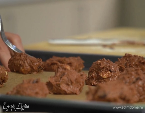 Сформировать из шоколадного теста шарики, выложить на выстеленный бумагой для выпечки противень и слегка сплющить вилкой.