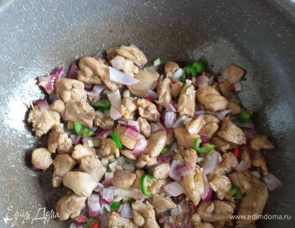 В ту же сковороду добавляем 2–3 столовые ложки растительного масла и жарим курицу 2–3 минуты, постоянно помешивая, на сильном огне до румяной корочки. Добавляем лук. Через минуту добавляем чеснок и перец чили. И кешью, если он у вас необжаренный, как у меня. Если кешью у вас уже обжаренный, то добавлять его нужно после яиц.