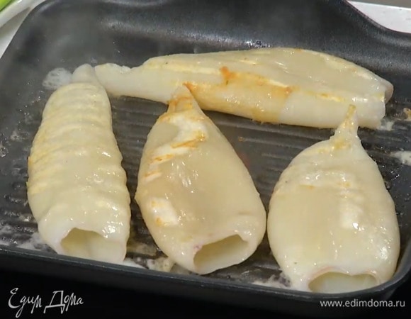 Смазать сковороду-гриль оливковым маслом и обжарить кальмаров до готовности с двух сторон.