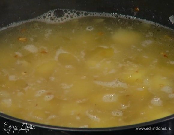 Сливочное масло растопить в сотейнике и обжарить лук практически до готовности, затем посолить, добавить картофель, все перемешать и залить горячим бульоном.