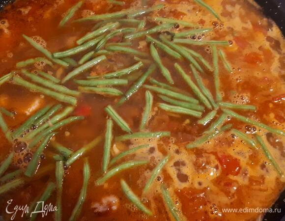 Влейте примерно стакан кипящего бульона, добавьте шафран, паприку и фасоль. Проварите на сильном огне 5 минут.