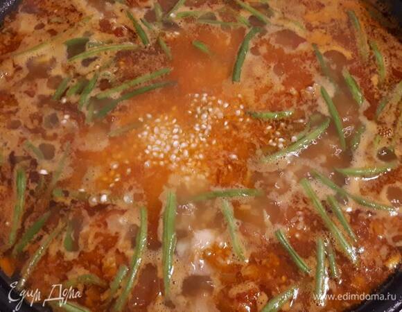 Всыпьте рис. Постарайтесь распределить его равномерно. Убавьте огонь до среднего.