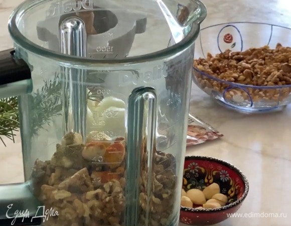 Грецкие орехи, очищенный и сушеный чеснок поместить в чашу блендера, добавить хмели-сунели, имбирь, куркуму, паприку, карри, сванскую и морскую соль и измельчить все так, чтобы остались маленькие кусочки орехов.