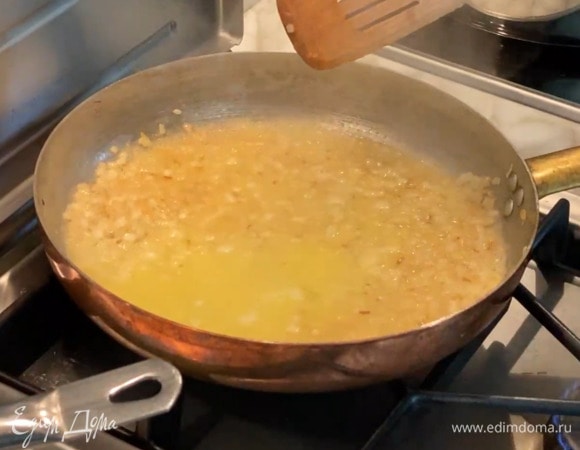 Оставшееся сливочное масло растопить в маленьком сотейнике, всыпать кукурузную крупу и, помешивая, немного обжарить, затем влить 200–250 мл бульона, все перемешать и отправить в сковороду с луком.