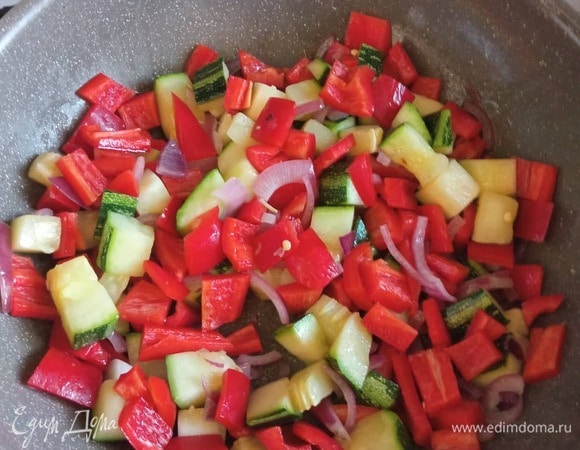 Затем доливаем масла и обжариваем нарезанный перьями или кольцами лук. Жарим 3 минуты, добавляем кабачки. Обжариваем 3–4 минуты, добавляем перец, болгарский и острый.