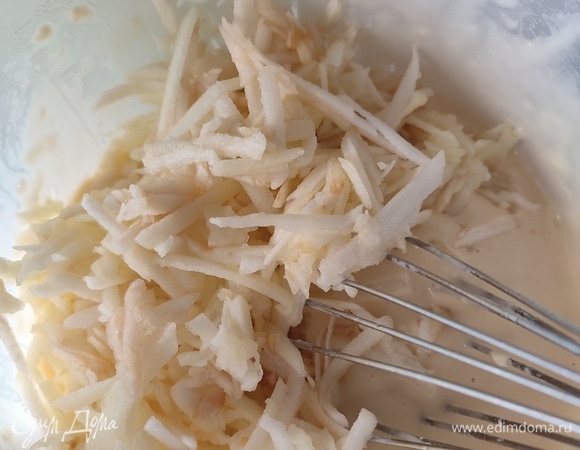 В смесь добавить муку с разрыхлителем. Размешать, чтобы не было комочков. Яблоки (у меня ушло 2 шт.) очистить от сердцевины и кожуры, натереть на крупной терке. Добавить яблоки к тесту и все еще раз перемешать до однородности.