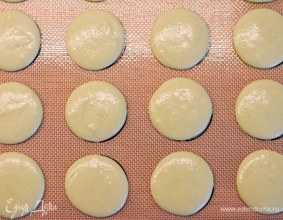 Переложить массу в кондитерский мешок и отсадить макарон на противень, застеленный пергаментом или специальным ковриком. Отстучать, чтобы избавиться от пузырьков воздуха.