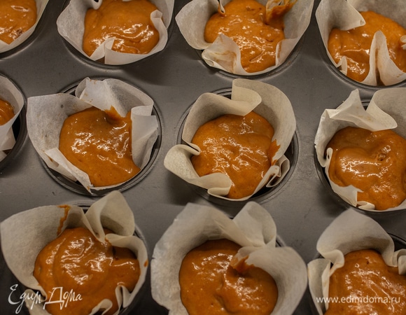 В форму для кексов вставить бумажные капсулы. Если нет бумажных капсул, можно сделать свои из квадратиков пергамента (как у меня на фото). Выложить тесто на 1/2 объема. Всего у меня получилось 12 штук.