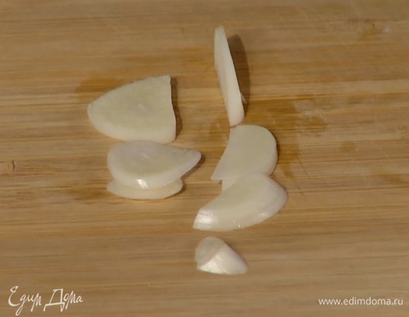 Чеснок почистить и нарезать лепестками.