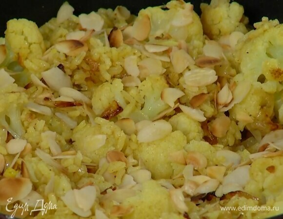 В готовый рис, удалив лавровый лист, добавить цветную капусту с луком, все перемешать и посыпать миндальными лепестками.