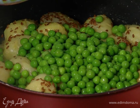 Размороженный зеленый горошек опустить на несколько минут в кипящую воду, затем откинуть на дуршлаг, всыпать к картофелю и перемешать.