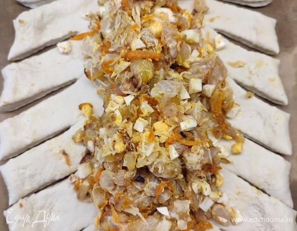 Тесто раскатать в продолготоватый пласт. На середину выложить начинку, по бокам сделать разрезы.