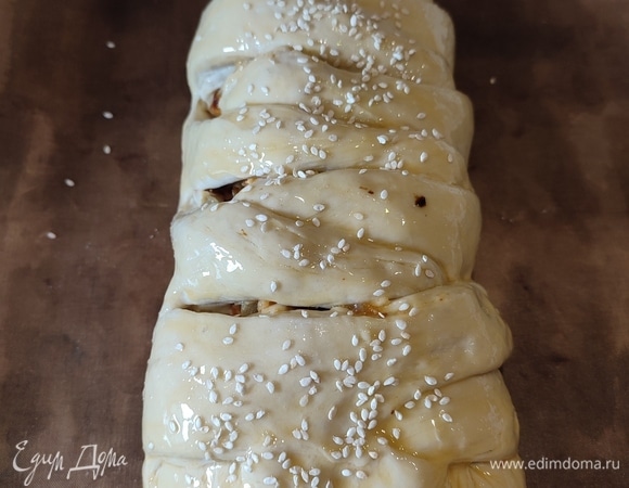 Закрыть начинку, разрезать в виде косички. Оставить пирог на 20 минут, чтобы подошел. Смазать яичным желтком, можно посыпать кунжутов. Выпекать 30 минут при температуре 200°C.