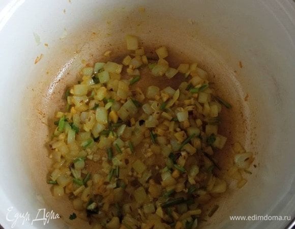 Мелко шинкуем репчатый лук, чеснок, имбирь, веточки мяты и кинзы (без листьев). В кастрюле с толстым дном раскаляем растительное масло и обжариваем лук 2 минуты, добавляем имбирь, чеснок, мяту и кинзу, карри, молотый перец чили и кумин. Обжариваем, постоянно помешивая, 1 минуту.