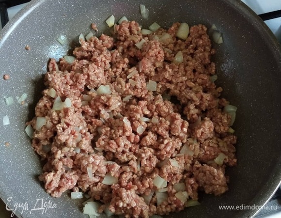 Мелко нашинкованный лук обжариваем в хорошо разогретом растительном масле 1 минуту. Добавляем фарш и жарим 3 минуты, добавляем 1 ст. л. молока и жарим еще 5 минут.