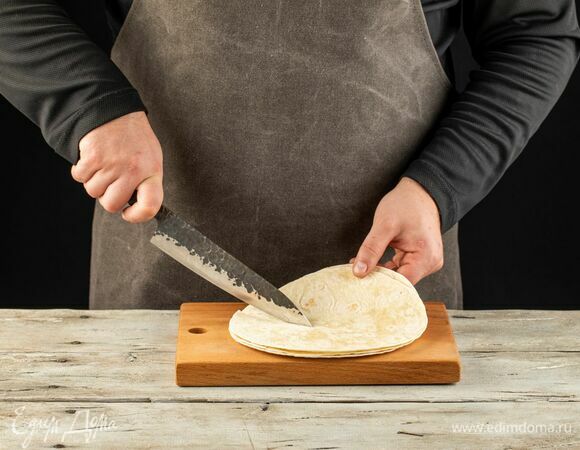 На тортилье сделайте один надрез от центра. Визуально разделите тортилью на 4 части.