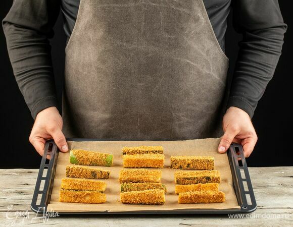 Выложите кабачки на противень, застеленный пергаментом. Запекайте в разогретой до 220°С духовке 15 минут.