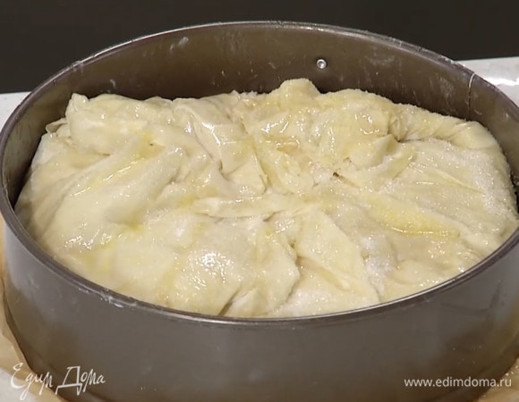 Накрыть яблоки оставшимися пластами фило, промазывая каждый маслом и посыпая сахаром, кроме последнего, затем завернуть свисающие края в центр формы, смазать маслом и присыпать оставшимся сахаром.