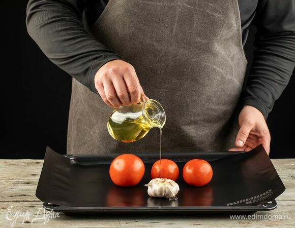 У чеснока срежьте верхушку, у помидоров проткните кожуру. Выложите на противень, застеленный мультипокрытием REDMOND, сбрызните оливковым маслом. Запекайте при 180°С помидоры — 15 минут, чеснок — 30 минут.