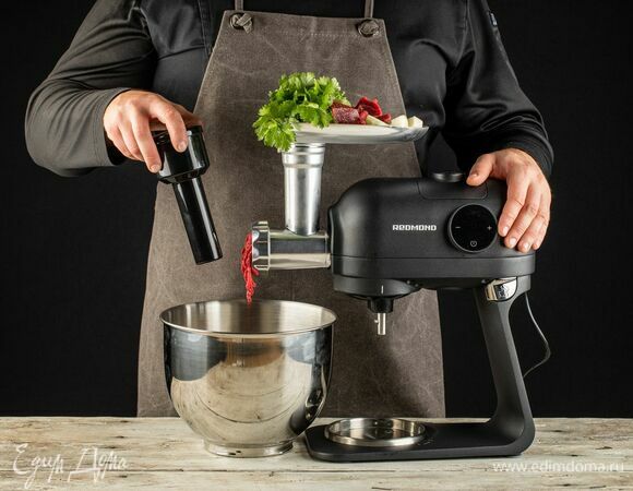 Затем установите на кухонную машину насадку-мясорубку. Говяжью шейку нарежьте небольшими кусочками, лук почистите и разрежьте пополам. С помощью мясорубки измельчите мясо, лук и кинзу.