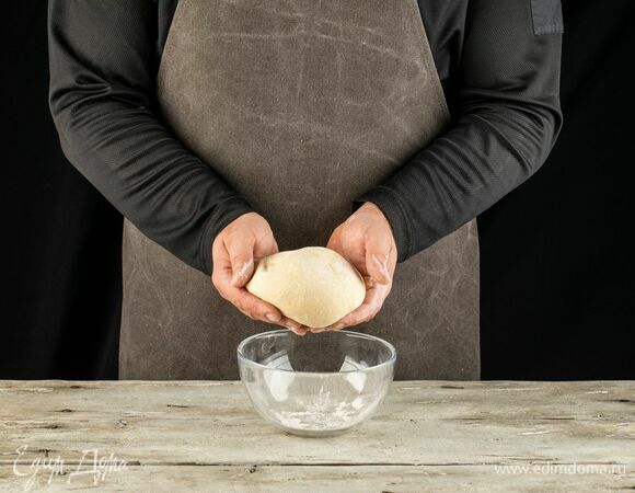 Скатайте тесто в шар, уберите в глубокую чашу, накройте ее пищевой пленкой и поставьте в теплое место на 1 час. Затем обомните заготовку и оставьте еще на 30 минут.