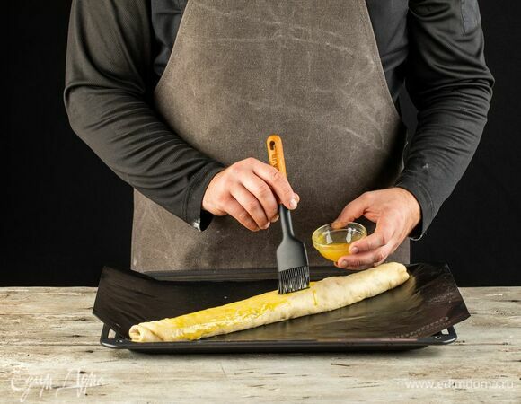 Переложите на противень, застеленный мультипокрытием REDMOND. Смажьте взбитым желтком, сверху по желанию еще немного посыпьте маком или орехами.