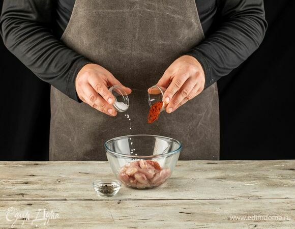 Куриные бедра нарежьте небольшими кусочками, посыпьте перцем, паприкой и солью.