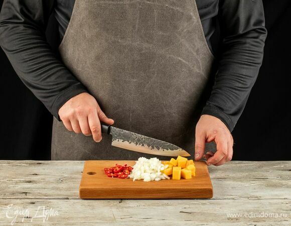 Тыкву почистите и нарежьте кубиками. Также нарежьте лук и перец чили.