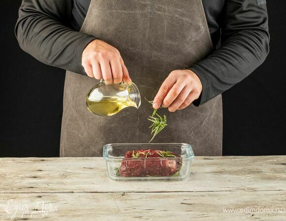 Положите туда же веточки розмарина, влейте оливковое масло. Поставьте мясо мариноваться в холодильник на 1 час.