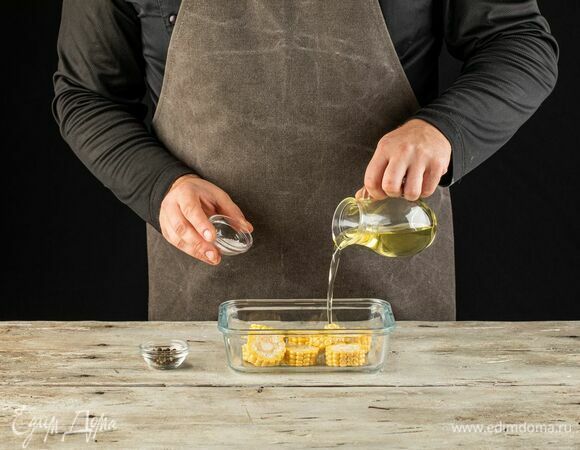 Кукурузу нарежьте кружками, полейте оливковым маслом, посолите, поперчите.