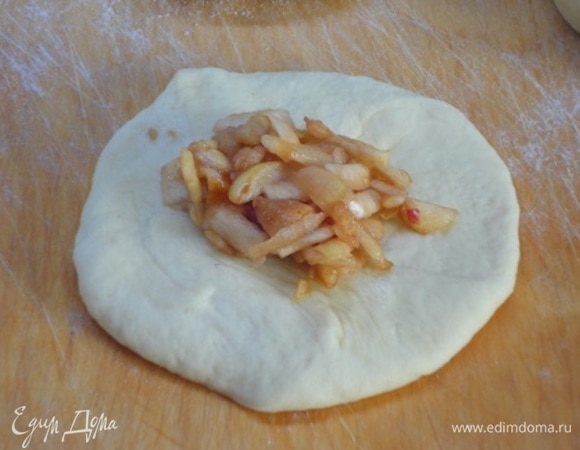 Подошедшее тесто разделить на шарики весом примерно 60 г, раскатать их в лепешки, в центр выложить по чайной ложке начинки и защипнуть края к центру.