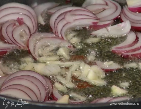 Чеснок почистить, мелко порубить и отправить к луку.