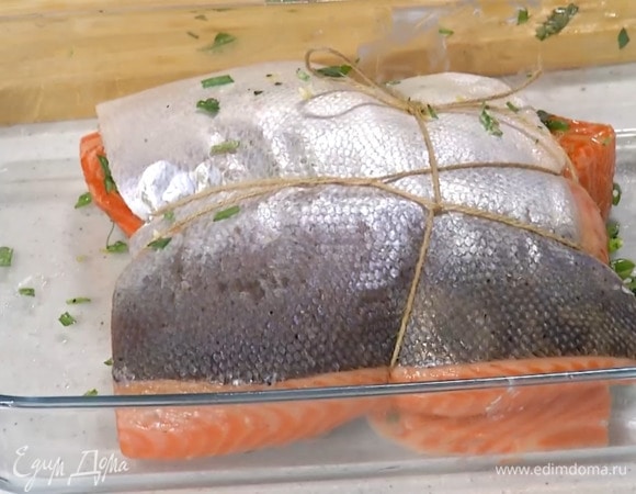 Семгу разрезать пополам, выложить кожей вниз и смазать предварительно размягченным сливочным маслом, на один кусок выложить зелень с чесноком, накрыть второй половиной и связать пищевой нитью.