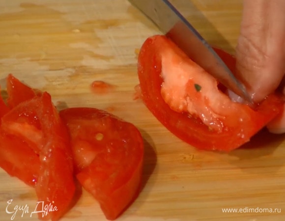 Помидор нарезать дольками, лишнюю жидкость и семена удалить.