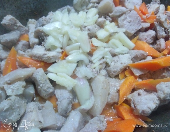 Затем добавить раздавленные зубчики чеснока. Жарить до аромата.